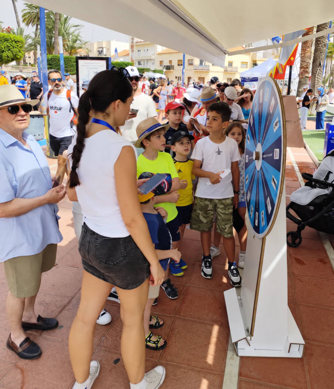 Personas participando en una activación real junto a una ruleta de premios.