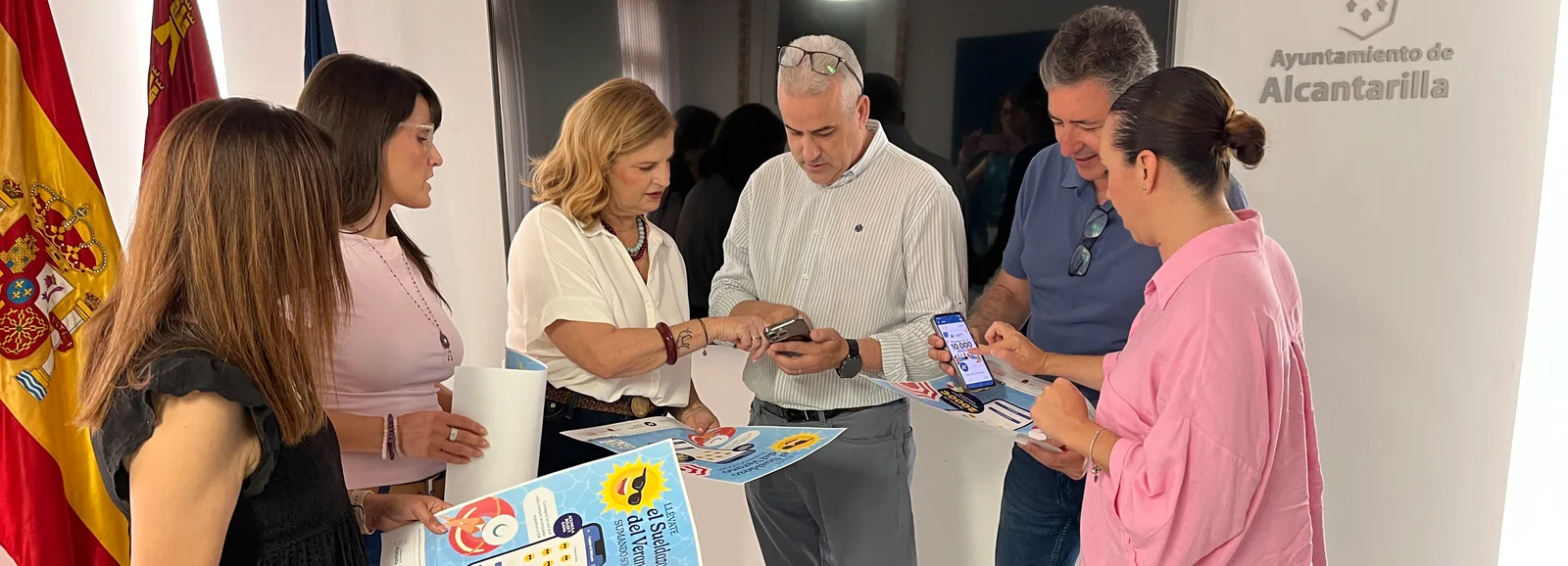 Técnicos del Ayuntamiento de Alcantarilla y de la asociación de comerciantes revisando en el móvil la campaña de la tarjeta regalo.